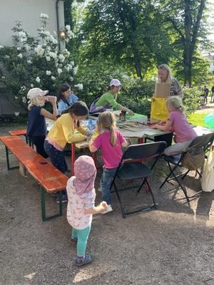 Eine Gruppe Kinder bespruehen Stofftaschen